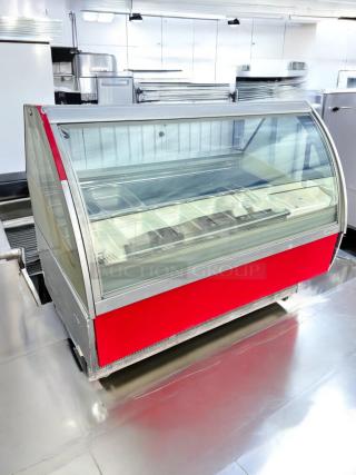 A red and silver commercial display cabinet with a glass front, designed for storing sheet pans, in a clean kitchen setting.