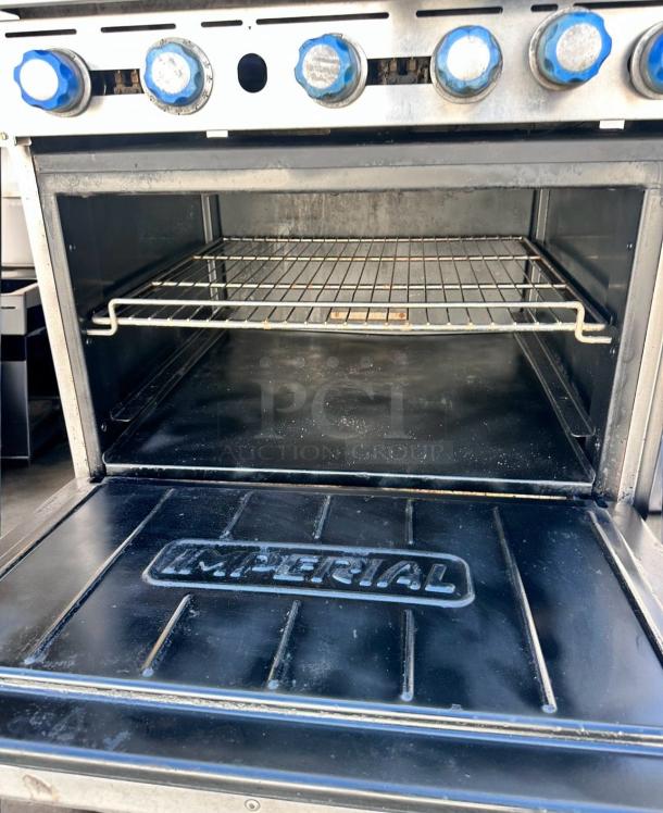 Imperial IR-6 36" gas range with 6 burners, standard oven, and blue knobs. Impeccable condition with visible branding.