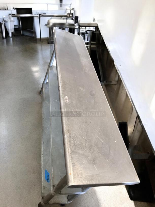 Stainless steel work table with two undershelves, 60" x 18", excellent condition, fully operational, tested, minor surface wear.
