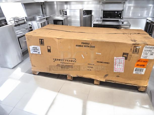 Factory sealed Henny Penny HHC900.24 heated holding cabinet in box. Features solid back, casters, and 120V compatibility.