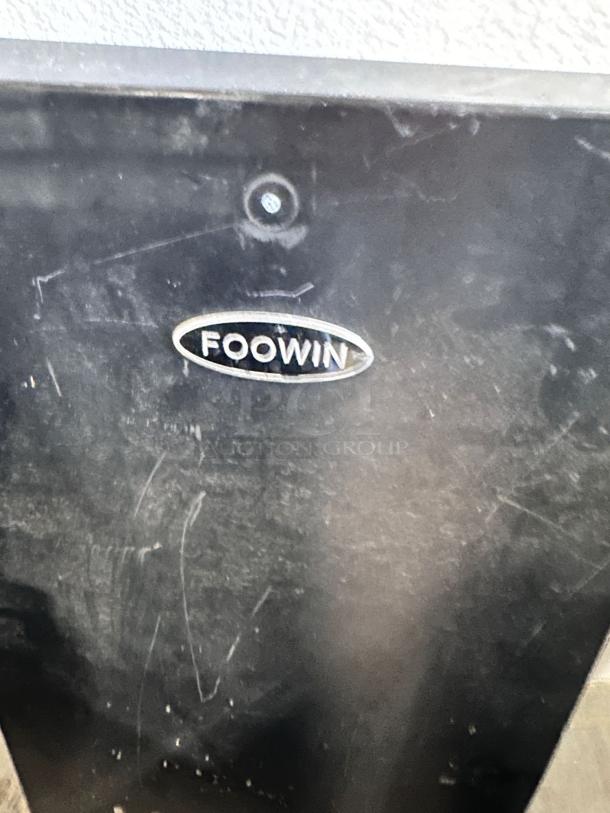 Foowin Patio Heater label close-up, showing "Foowin" logo on black surface. Heater is an excellent condition model CAPH-GT-S.