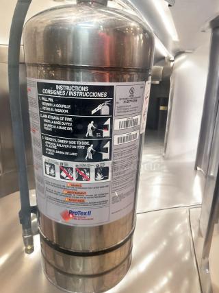 ProTex II KS6100 wet chemical fire extinguisher, stainless steel, excellent condition, fully tested; instruction label visible.
