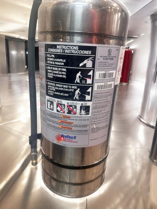 ProTex II KS6100 fire extinguisher, stainless steel, excellent condition, fully tested and operational, visible instructions label.
