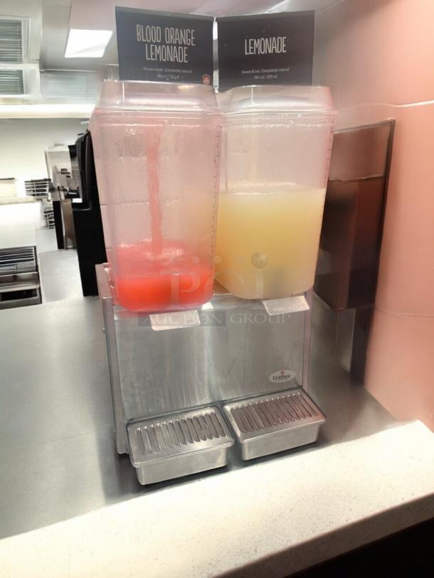 Crathco D25-3 dual tank cold beverage dispenser, excellent condition, 115V, fully tested, labeled for Blood Orange and Lemonade.