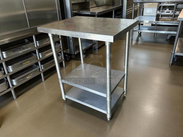All stainless steel worktable, 30" W x 24" D x 36" H, excellent condition, with quality gauge and two lower shelves.