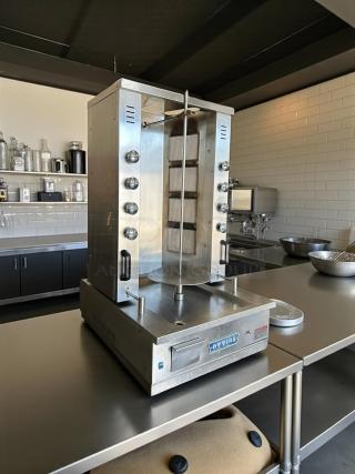 Attias GRY-8 electric gyro machine, 8 burners, 100lbs capacity, in outstanding condition. Model label visible. Tested & working.