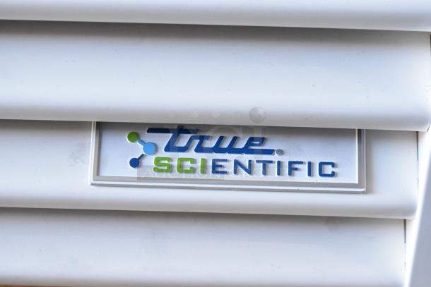 True Scientific logo on a label attached to the metal surface of a commercial cooler.
