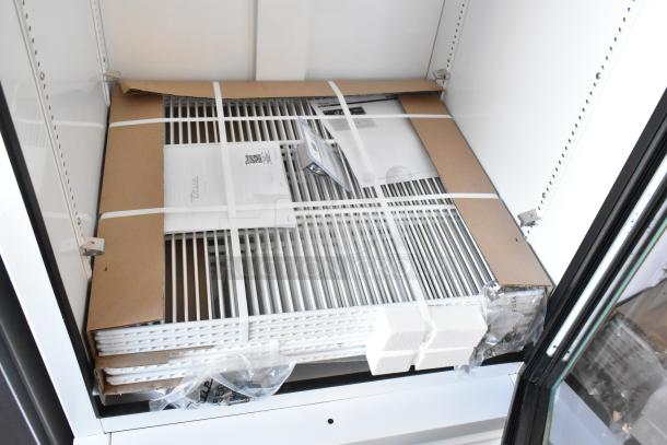 Brand new True TSCI-600R-G-PH commercial cooler interior; metal racks, poly coating, packaging materials visible.