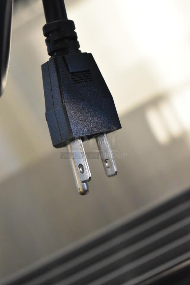 Close-up of a power plug for the Vollrath RDE8148 refrigerated display cabinet, showcasing standard voltage.