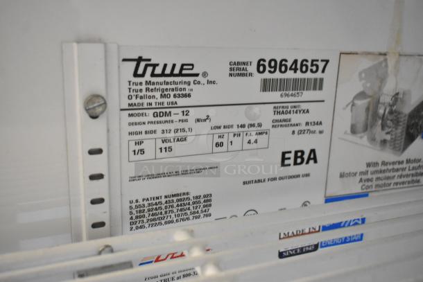 True GDM-12 metal commercial cooler, single door, poly coated racks, 115V, 1 phase. Features serial and model tags.