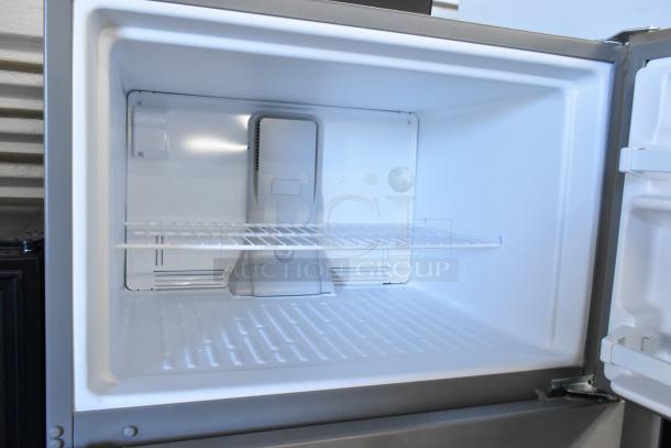 Whirlpool WRT311FZDM05 stainless steel freezer interior, brand new, single shelf, showing spacious and clean condition.