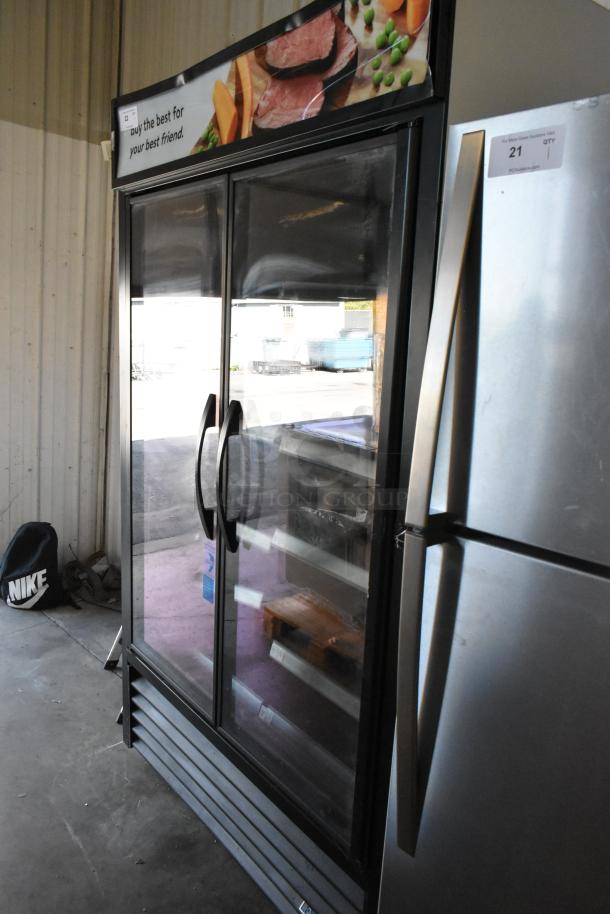 2022 True TVM-48SL-HC commercial 2-door reach-in cooler, metal shelves, 115V, good condition, grocery signage on top.