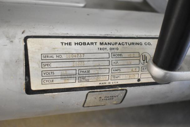 Hobart 1612 commercial meat slicer, metal, 115 volts, 1 phase, with visible manufacturing label and specs.