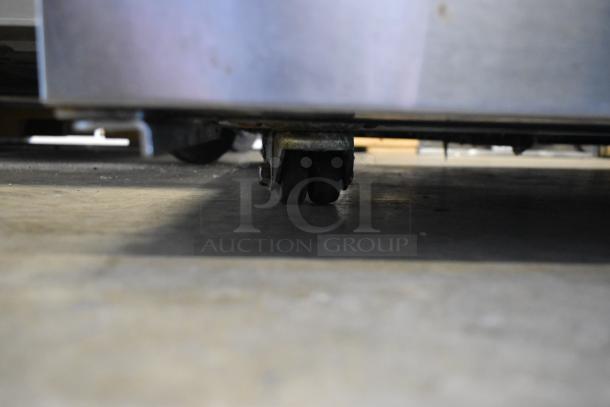 True TUC-48F-LP stainless steel undercounter freezer on commercial casters, 115V, showing durable caster detail.