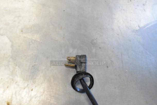 A power plug on a metal surface, likely part of the True TUC-48F-LP commercial freezer.
