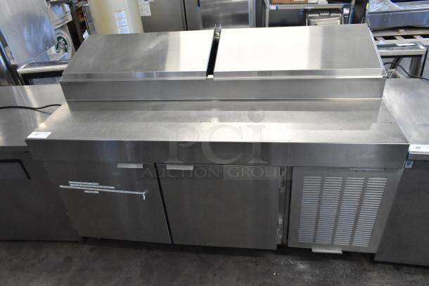 Stainless steel commercial pizza prep table on casters, 115 volts, 1 phase, with undercounter storage and stainless finish.