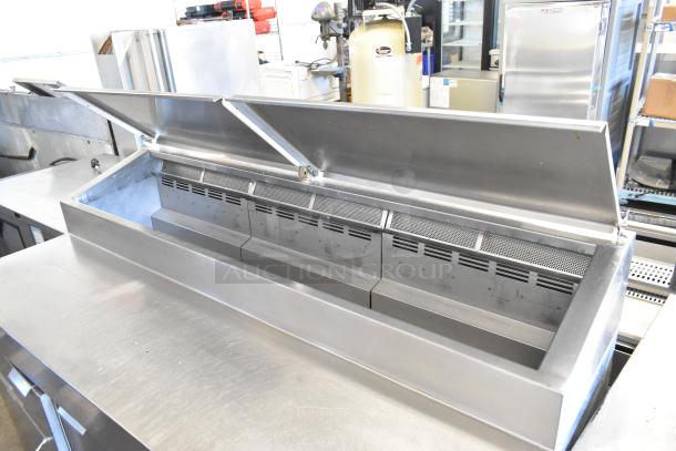 Stainless steel commercial pizza prep table on casters, dual lids open, 115 volts, 1 phase, excellent condition.