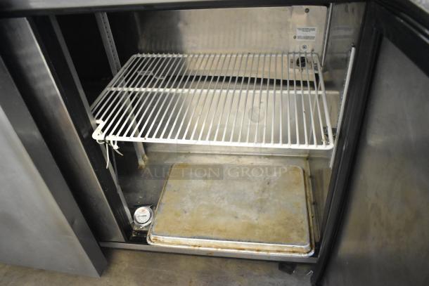 True TUC-48F-LP stainless steel commercial 2-door undercounter freezer, visible interior shelf, on commercial casters. 115 volts, 1 phase.