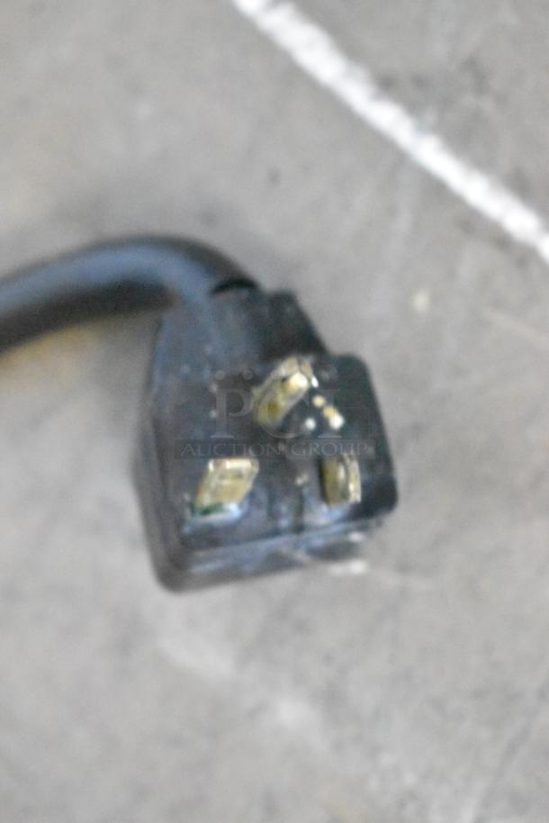 A close-up of a plug for the Randell 84111NM stainless steel commercial pizza prep table, compatible with 115 volts, 1 phase.
