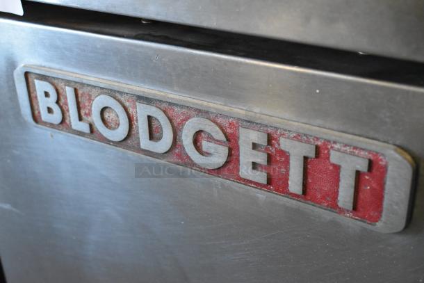 Blodgett stainless steel commercial convection oven with solid doors, metal racks, thermostatic controls, and metal legs.