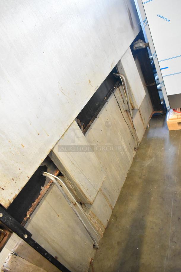 Garland metal commercial gas-powered flat top griddle with 2 ovens, over shelf, and backsplash. Used condition.