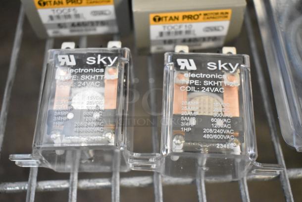 Lot of electronic components including Sky Electronics encapsulated pressure control, type SKHTT-20, 24VAC coil, and Titan Pro run capacitors.