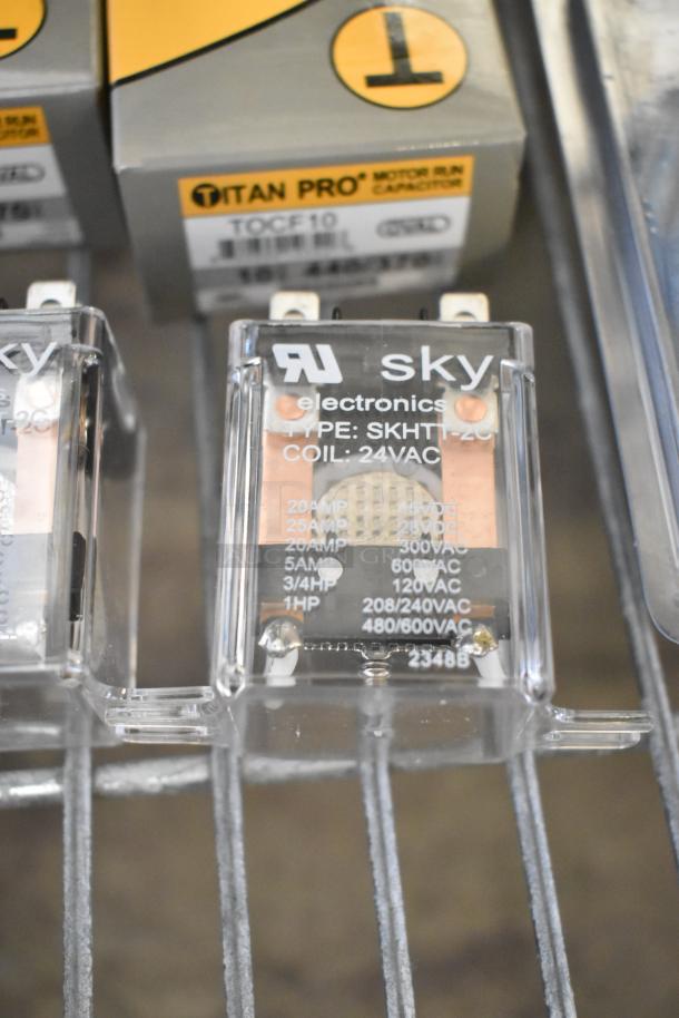Lot of various items including Titan Pro run capacitors and Sky Electronics encapsulated pressure control, model SKHTT-2C, coil 24VAC.