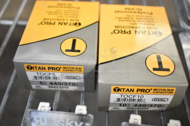 Titan Pro run capacitors TOCF5 and TOCF10, oval, 5 and 10 MFD, 440/370V, displayed in original packaging.