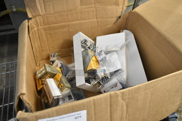 Box of various items including encapsulated pressure controls and Titan Pro run capacitors in original packaging.