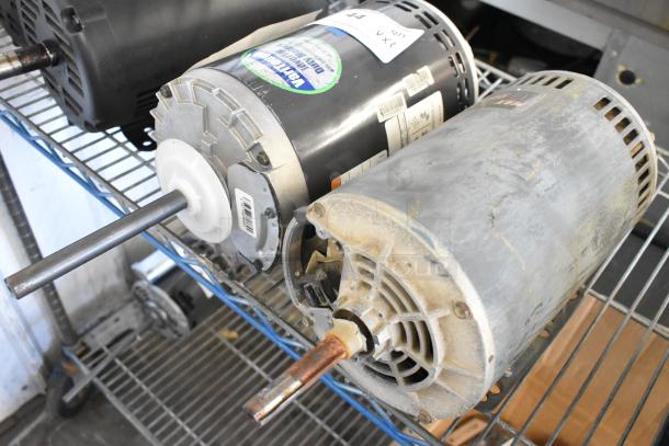 Two industrial motors: Marathon WG55T8O15516A and US Motors J63WZBKH-0246, 208-230/460V, 3-phase, on a metal shelf.