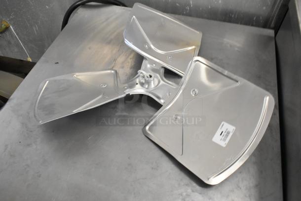 Shiny metal fan blades with mounting hub, auctioned as a set of three. Includes barcode label. Appears in good condition.