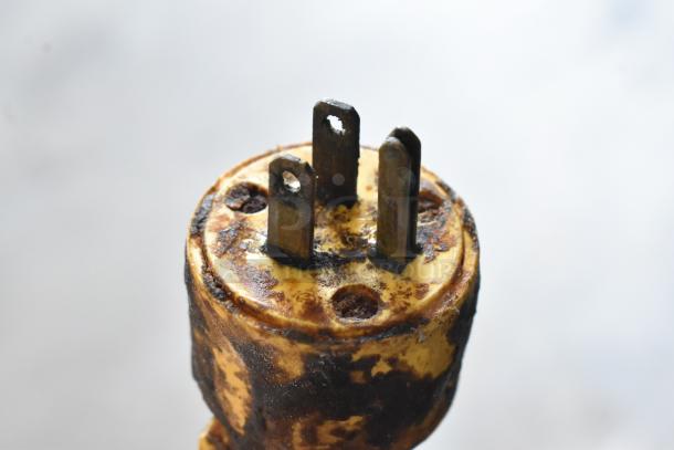 Close-up of a worn, rusted plug from a Hobart H-600 commercial mixer. Metal prongs show signs of oxidation.
