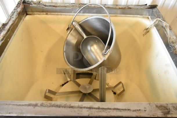 Cornelius ED200-BCHZ beverage machine interior with stainless steel bucket and scoop. Slight wear visible on edges.