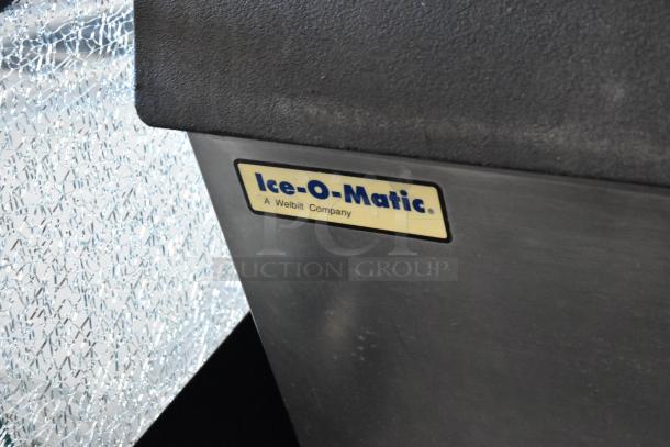 Manitowoc QD0452A stainless steel ice machine on Ice-O-Matic bin, with commercial casters. Label reads "Ice-O-Matic, A Welbilt Company."