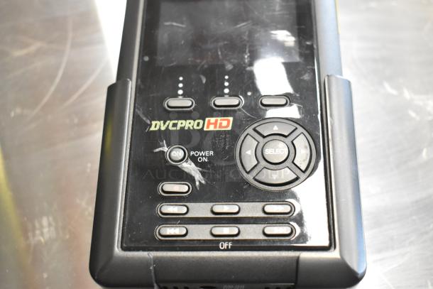 Black DVCPro HD device with display and controls. Scratched surface. Includes power and navigation buttons.