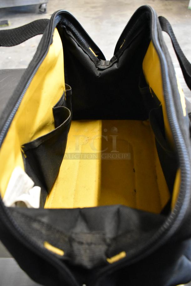 Black and yellow fabric bag interior, featuring multiple compartments and pockets. Condition appears lightly used.