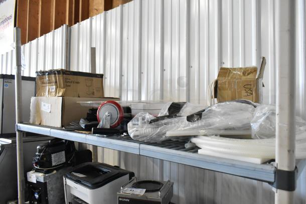 Auction shelf lot with commercial casters, flared coupe glass box, and various sealed items. Some boxes labeled "USA."