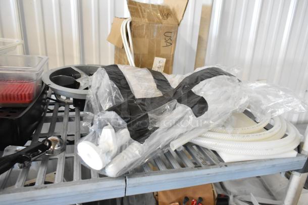 Tier lot including commercial casters, flared coupe glass, and seals on a metal shelf. Items appear in good condition.