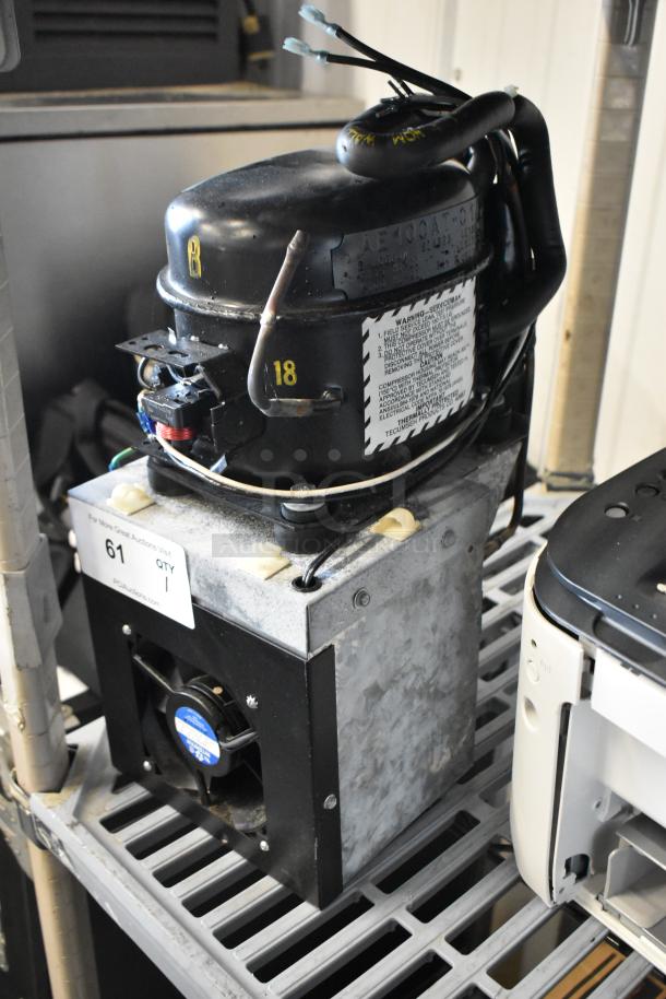 Baxter Mini K 1416 Compressor, 115V, 1 phase. Includes visible labels and wiring. Used condition on a grated shelf.