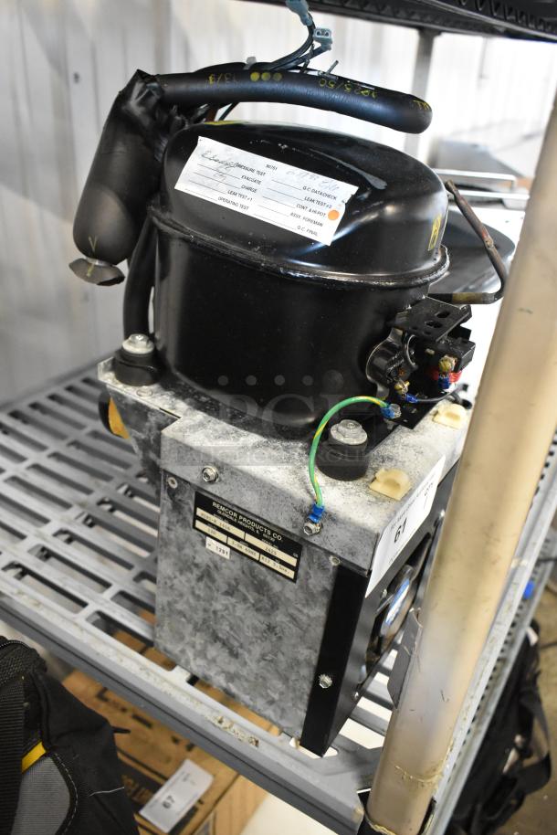 Baxter Mini K 1416 Compressor on shelf, 115 volts, 1 phase; features visible wiring and labels, indicating specs and manufacturer.