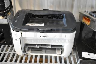 Canon F166500 printer, monochrome model, visible scuffs, front paper tray open, auction tag marked "62", function condition unknown.