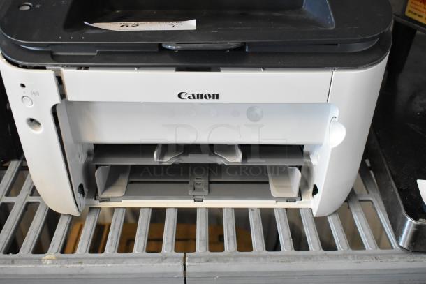 Canon F166500 printer, white and black, open paper tray, minor wear, Canon logo visible, suitable for home or office use.