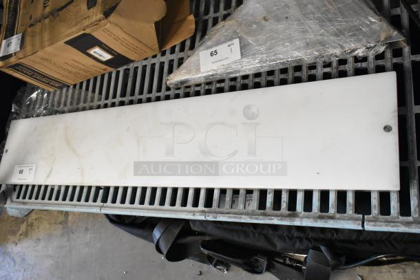 White cutting board with visible wear, rectangular shape. Auction tag labeled "68" and marked by PCA auctions.