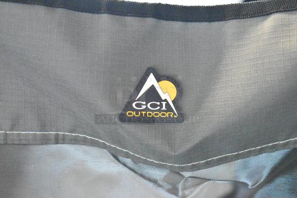 GCI Outdoor gray collapsible chair, featuring durable fabric, with a logo patch displaying a mountain design and company name.
