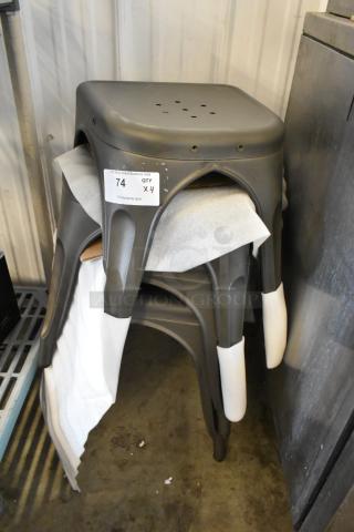 Four metal gray Tolix style stools, stackable, industrial design. Includes label showing quantity and auction info.