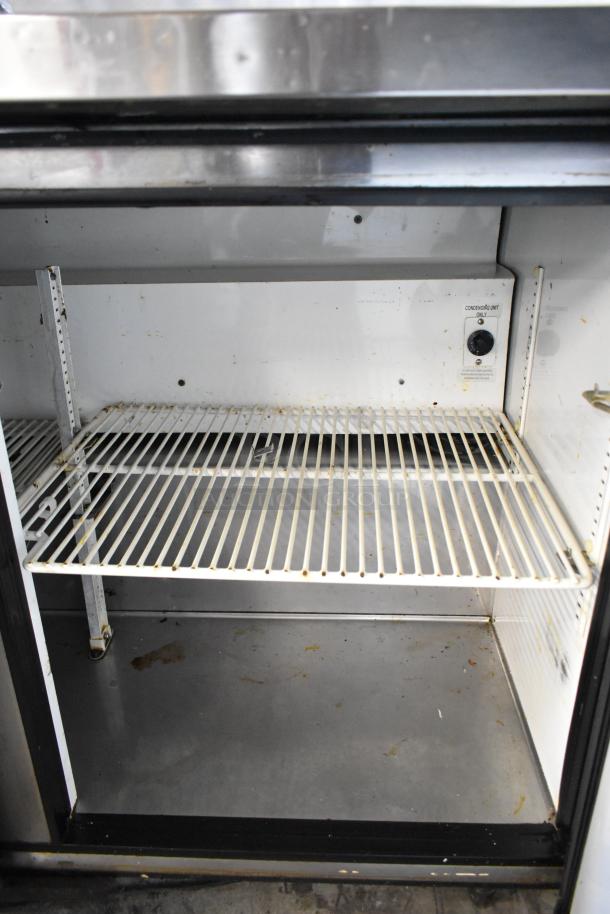 True TSSU-48-12 stainless steel commercial prep table with bain marie top; 115V, 1 phase; interior view; shelves shown.