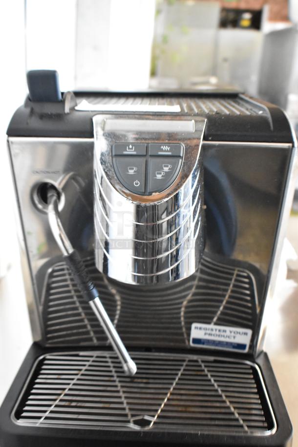 Brand new metal commercial countertop espresso machine with steam wand; slight scratches, otherwise unused. Control panel and drip tray visible.