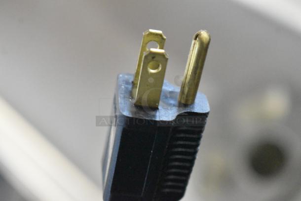 Close-up of a power plug for the Pro-Cut KG-22W electric meat grinder, showing details of the plug prongs.