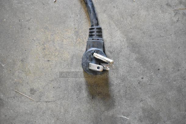 Close-up of a three-prong power cord plug on a concrete surface, likely part of the Habco SE18 cooler.