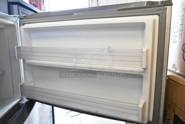2016 Whirlpool WRT511SZDM00 stainless steel cooler with freezer, open door view showing interior storage shelves.